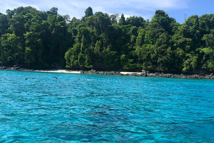Turquoise water in front of a forested island in Coiba National Park